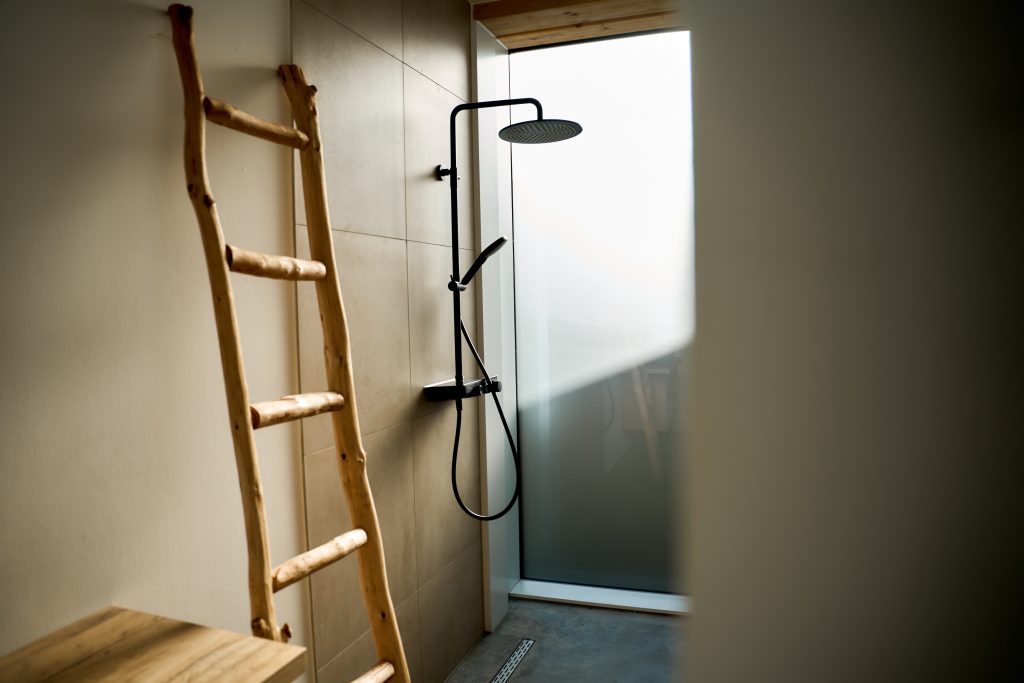 gecreëerde inloopdouche, badmeubel, achter een wand in de slaapkamer