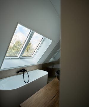 Maatwerk badkamer met inloopdouche onder schuindak voor optimaal ruimtegebruik